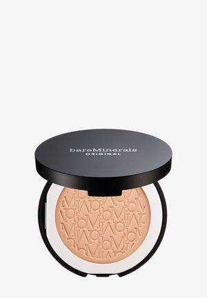Polvo compacto con una tapa negra, que presenta una marca en relieve. El polvo interior es de color beige claro y tiene una textura suave. Base blanca.