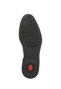 Suola di gomma nera con motivo esagonale per trazione, caratterizzata da un dettaglio rosso vicino al centro e logo impresso.