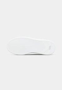 Λευκή σόλα παπουτσιού από καουτσούκ με κυματιστή υφή και στρογγυλεμένες άκρες. Εκτυπωμένο λογότυπο κοντά στη φτέρνα και σχέδιο πρόσφυσης για καλύτερο κράτημα.