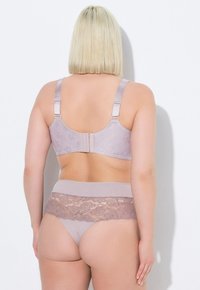 Jasnofioletowy biustonosz z koronkowymi wykończeniami i regulowanymi ramiączkami, w komplecie z pasującymi jasnofioletowymi majtkami z koronkowym paskiem.