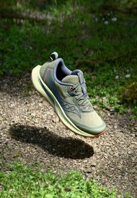 Chaussures de course pour hommes en vert olive, avec une tige en tissu texturé, des accents orange, une semelle rembourrée et un design léger.