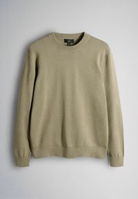 Pull en maille beige avec col rond, manches longues, poignets et ourlet côtelés. Texture douce avec une finition lisse, conçu pour un usage décontracté.