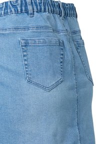 Ljusblå denimkjol med elastisk midja. Har en bakficka och en slät yta. Sömmen faller ovanför knäet.