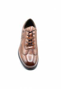 Chaussure en cuir marron avec un bout arrondi, un laçage sur le devant et des coutures décoratives. Texture lisse et léger éclat. Semelle en caoutchouc noire.