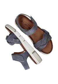 Grijze suede sandalen met een gevlochten band ontwerp, witte rubberen zool en een bruine leren binnenzool. Verstelbare enkelband voor een goede pasvorm. Maat 38.