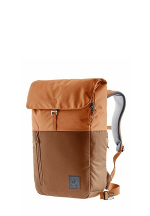 Un sac à dos en tissu marron avec un système de fermeture enroulable, une poche zippée sur le côté, des bretelles rembourrées et un patch logo à l'avant.