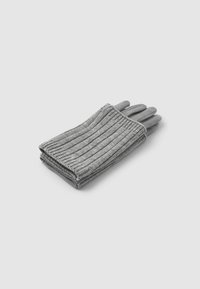 Gants en tricot gris avec une texture côtelée et un ajustement serré. Les bouts des doigts sont lisses, s'harmonisant avec la couleur et le design des gants.