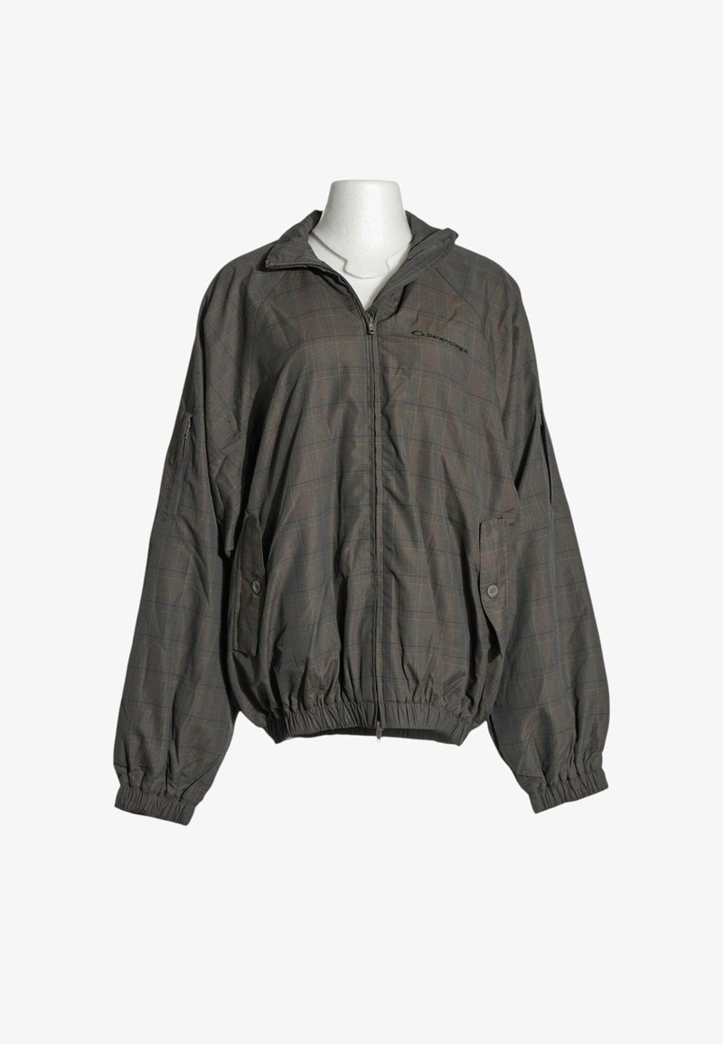 Veste légère gris foncé avec motif à carreaux subtil, fermeture éclair complète à l'avant, poches latérales boutonnées et poignets et ourlet élastiques.