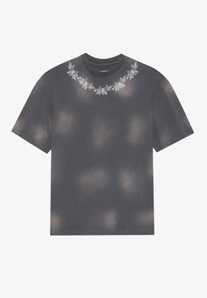 T-shirt grigio scuro con una vestibilità rilassata, caratterizzato da un design floreale ricamato attorno al collo e un motivo tie-dye su tutta la superficie.