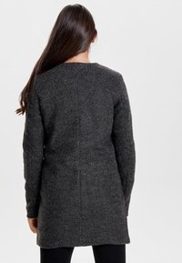 Grauer Wollmantel mit strukturiertem Design, langen Ärmeln und geradem Schnitt, mit einer Rückennaht und strukturiertem Stoff.