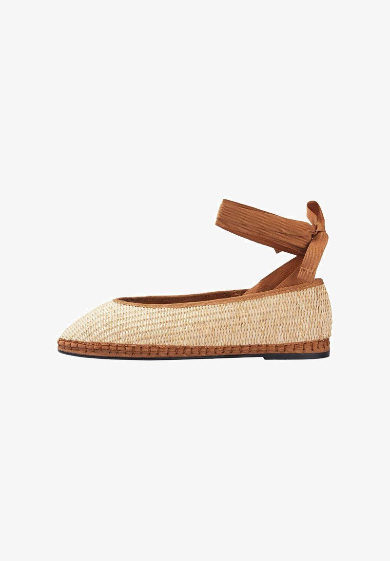 Chaussure en paille tissée à enfiler avec un bout pointu, bride de cheville en tissu marron et semelle plate marron. Surface texturée et fibres naturelles visibles.