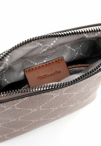 Sacchetto grigio testurizzato con un motivo geometrico, etichetta in pelle e cerniera argento. L'interno foderato presenta un design sottile con elementi circolari.