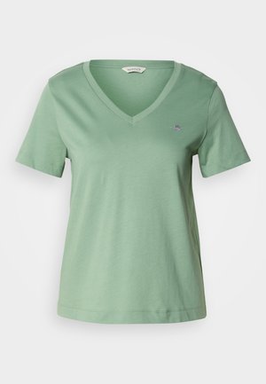 Roheline puuvillane T-särk V-kaelusega ja lühikeste varrukatega. Sellel on rinnal väike kirjadud logo ja vaba lõige.