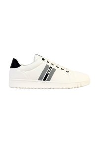 Zapatilla blanca con un acabado de cuero suave, acentos negros en el talón y dos rayas diagonales negras en el costado. Suela de goma con agarre texturizado.