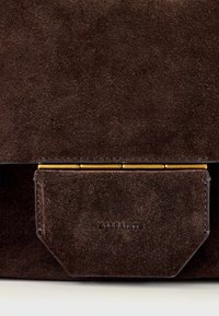 Bruine suède clutch tas met een goudkleurige hardware-accent en geperst logo detail. Soepele textuur met een rechthoekige vorm en klepsluiting.