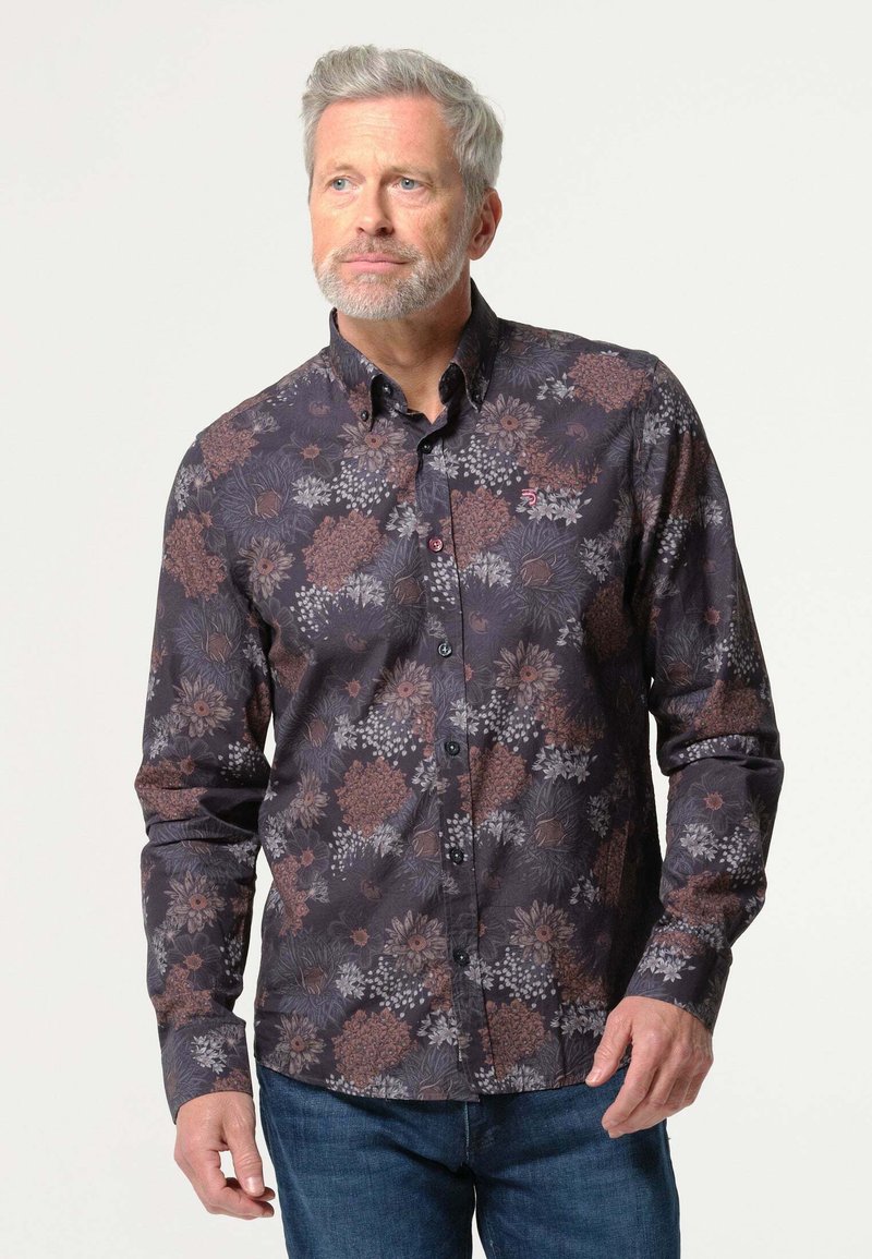 Langarmshirt in donkere stof met een bloemenpatroon in tinten van oranje, grijs en wit; knoopsluiting en zwarte knopen.