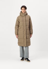 Manteau rembourré marron, longueur genoux avec un col montant, fermeture éclair à l'avant et deux poches latérales. Le matériau est matelassé avec une texture douce.