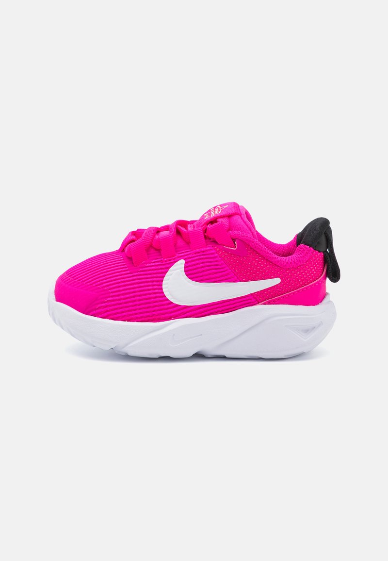 Pink athletic shoe with ribbed fabric, white Nike Swoosh logo, padded collar, black accent at heel, and white midsole.