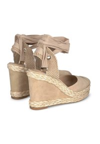 Bottines compensées en espadrilles beige avec un dessus en tissu texturé, des détails en jute tissés et de douces lanières pour maintenir autour de la cheville.