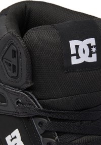 Juodas aukštas sportbačius, kurių viršutinė dalis pagaminta iš tekstūruoto audinio, su paminkštinta apykakle ir balta DC logotipu. Su raišteliais, sustiprintais akies angomis.