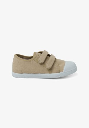 Chaussure en toile beige avec une coque en caoutchouc blanc, deux courroies Velcro ajustables, un dessus texturé et une semelle en caoutchouc flexible.