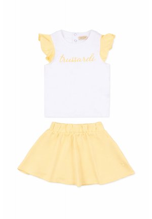 Top bianco senza maniche con maniche arricciate gialle e scritta "trussardi", abbinato a una gonna gialla con vita elastica per ragazze.