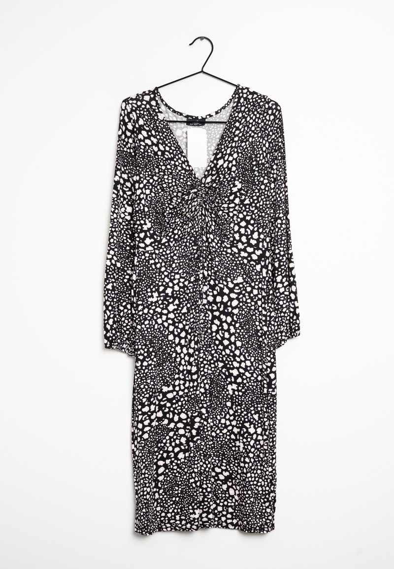 Mustavalkoinen kuviollinen mekko, jossa on syvä V-pääntie, pitkät hihat ja kerroksellinen etuosa, joka sisältää sekoituksen orgaanisia muotoja.