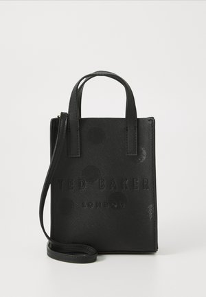 Czarna, teksturowana torebka Ted Baker London z dwoma krótkimi uchwytami i długim, odpinanym paskiem, stojąca pionowo na białej powierzchni.