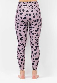 Pink leggings with large black spotted pattern, made of stretchy material, featuring a high waistband and a smooth texture.