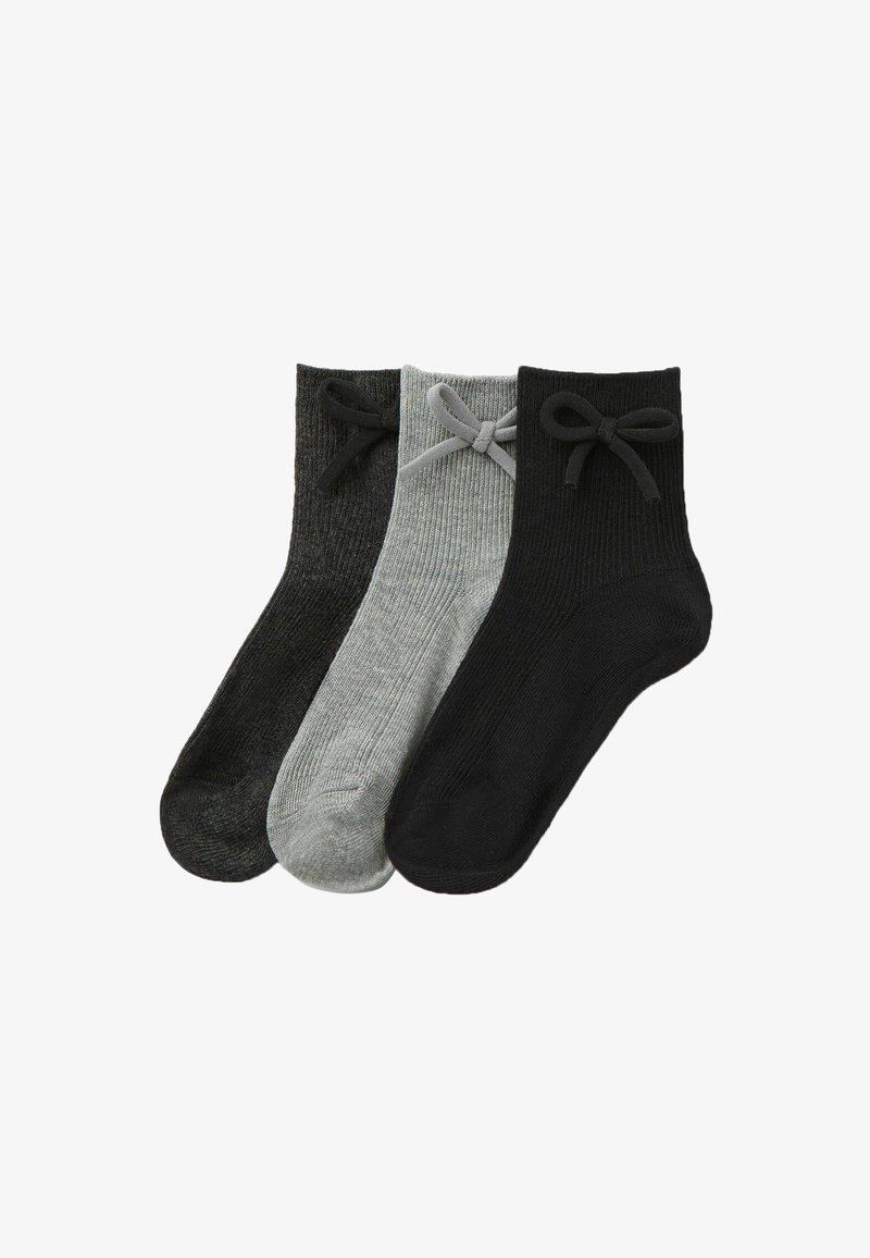 Lot de trois paires de chaussettes à cheville en noir, gris foncé et gris clair. Caractéristiques : texture côtelée et nœuds sur les poignets. Matériau en mélange de coton.