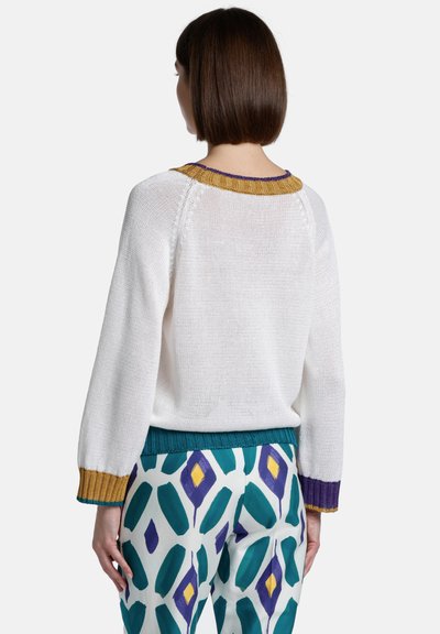 Knitted white sweater with a textured finish; features multicolored accents in gold, teal, and purple at the collar and cuffs.
