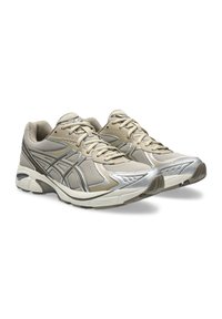 Beige athletic shoes with silver accents; mesh and synthetic upper, lace closure, padded collar, and textured rubber outsole.