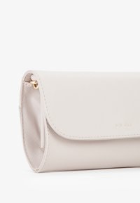 Clutch beige chiaro con un'esterno strutturato, hardware dorato e chiusura a pattina. Include uno scomparto interno per carte per una migliore organizzazione.