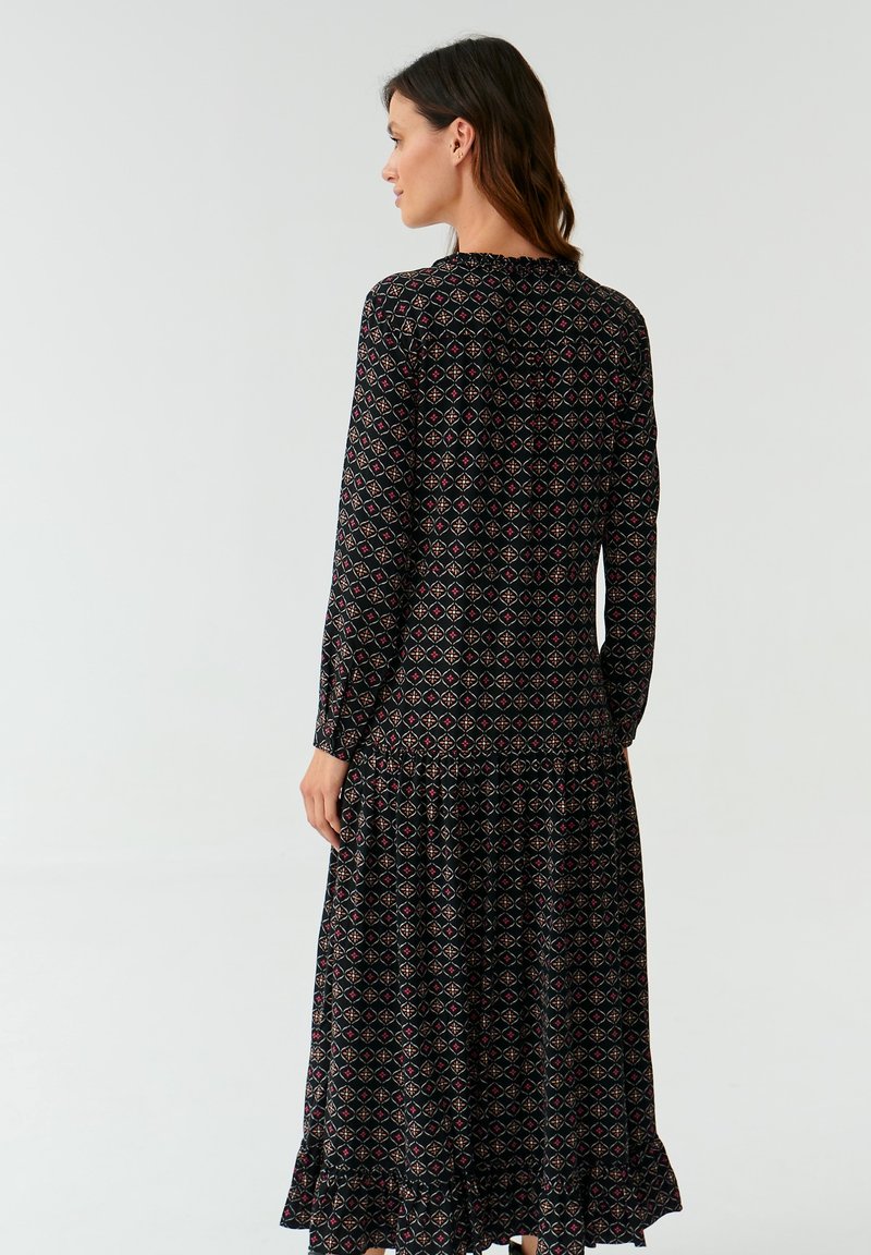 Czarna, długa sukienka maxi z długim rękawem, zdobiona wzorem w diamenty w odcieniach czerwieni i niebieskiego. Zandystwa w talii oraz falbaniasty dół. Miękka tkanina o zwiewnym fasonie.