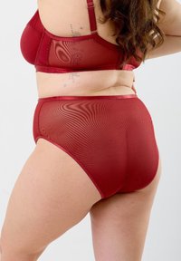 Ribbad röd lingérie-set med en nätdesign, justerbaraaxlar och en högmidjad trosor med en slät midja och subtil lyster.