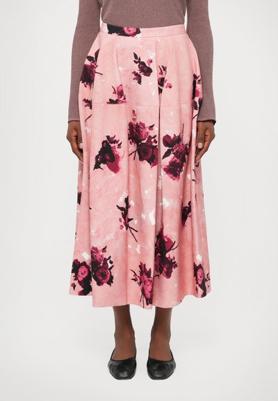 Jupe midi rose avec un motif floral en rouge foncé et des accents blancs. Présente des plis et une ceinture, fabriquée en tissu texturé.