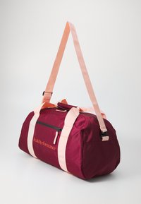 Bordeaux reistas met roze banden, voorzien van een voorvak met rits en branding. Gemaakt van duurzaam materiaal met een soepele textuur.