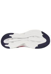 Suela de zapato con una base blanca, que presenta una sección de goma negra texturizada en el talón y un diseño ondulado y estampado para mayor agarre.