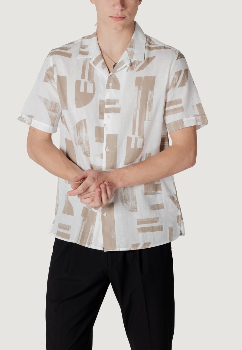 Korte mouwen shirt in witte linnen met abstracte tan patronen, knoopsluiting aan de voorkant en een losse pasvorm. Gestyled met zwarte broeken.