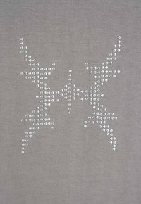 Symetryczne poroża renifera i środkowy wzór gwiazdy wykonany z małych srebrnych ćwieków na szarej dzianinie.