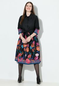 Abito nero con stampa floreale in colori vivaci, chiusura con bottoni frontale, maniche a tre quarti, vita legata e dettaglio a motivo sull'orlo.