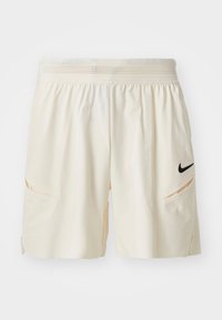 Pantaloni corti color crema chiaro realizzati in tessuto morbido, con cintura in rete, due tasche laterali e un piccolo logo Nike nero sulla coscia sinistra.
