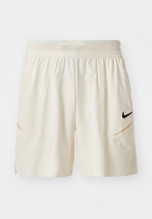 Light cream shorts made of soft fabric, featuring a mesh waistband, two side pockets, and a small black Nike logo on the left thigh.