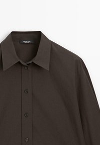 Chemise marron foncé à manches longues boutonnée avec col classique, quatre boutons visibles et étiquette Massimo Dutti à l'intérieur du col.