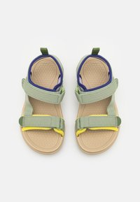 Gröna och lila öppetåiga sandaler med justerbara remmar, gula accenter och en texturerad tan sula. Lättviktsdesign för komfort.