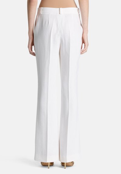 Witte linnen wijde broek, met een hoge taille en plooien, een gladde textuur en gestructureerd silhouet, gecombineerd met bruine hakken.