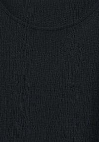 Tessuto nero con un motivo texturizzato e sgualcito, e una scollatura rotonda. Il materiale appare leggero e leggermente elasticizzato.