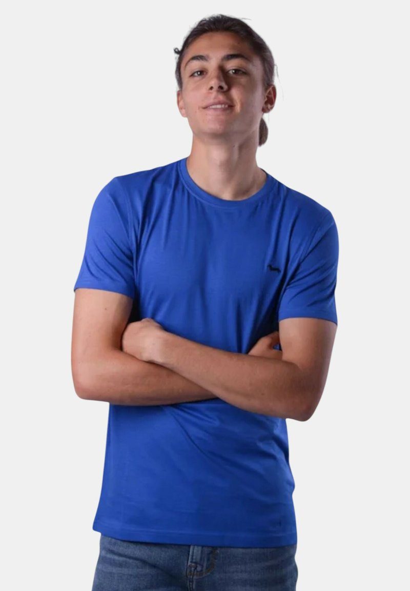 T-shirt a maniche corte di un blu reale, realizzato in tessuto liscio, con colletto rotondo e un dettaglio minimalista del logo nero sul petto.