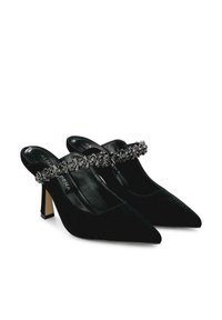 Zapatos de tacón slingback de ante negro con punta afilada, tirante decorado con cristales transparentes y un tacón bajo tipo bloque.