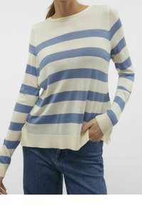 Pull en maille léger à rayures bleues et crème, col rond et poignets côtelés. Présente une coupe décontractée et des fentes latérales à l'ourlet.